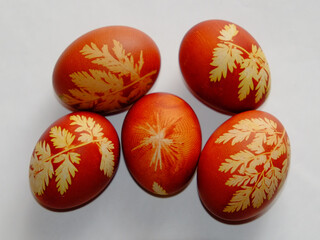 Painted Easter eggs on a white background. Floral pattern on a red eggshell. Festive food.