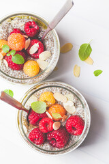 Chia pudding with berries in glass jar, white background. Healthy food concept.