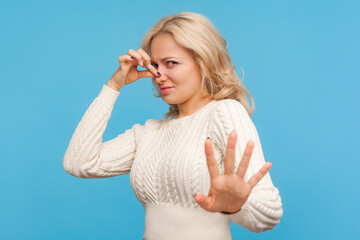 Scared with disgusted odor blond woman grabbing her nose with fingers, bad reaction on dirt,...