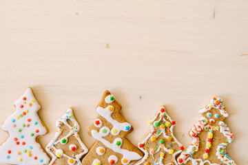Gingerbread, handmade treats. Decorated Christmas trees with sprinkles and glaze on a white background.