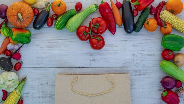 Vegetables in a brown paper bag on a white wood background, stop motion animation