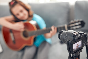 Obraz na płótnie Canvas Child guitarist making video lessons and tutorials for internet vlog website classes.