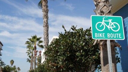 Bike Route green road sign in California, USA. Bicycle lane singpost. Bikeway in Oceanside pacific tourist resort. Cycleway signboard and palm. Healthy lifestyle, recreation and safety cycling symbol