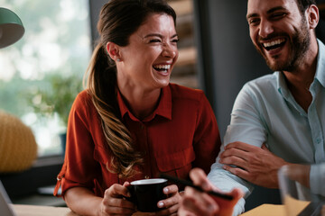 Businessman and businesswoman in office. Two friends drinking coffee while working on the project..