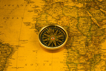 Fototapeta na wymiar Compass on old map of the world. Journey and discovery concept
