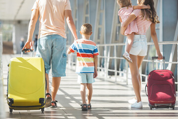 Happy family at the airport with suitcases traveling