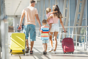 Happy family at the airport with suitcases traveling