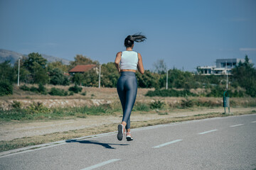 A beautiful woman runing on street in sportswear.