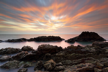 Sea and rocks with beautiful sunset in the background
