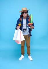 Funny happy Asian man backpacker on blue background.