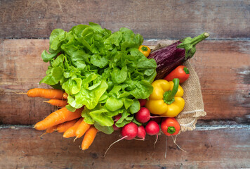 Fresh seasonal vegetables in a box on a wooden base - top view