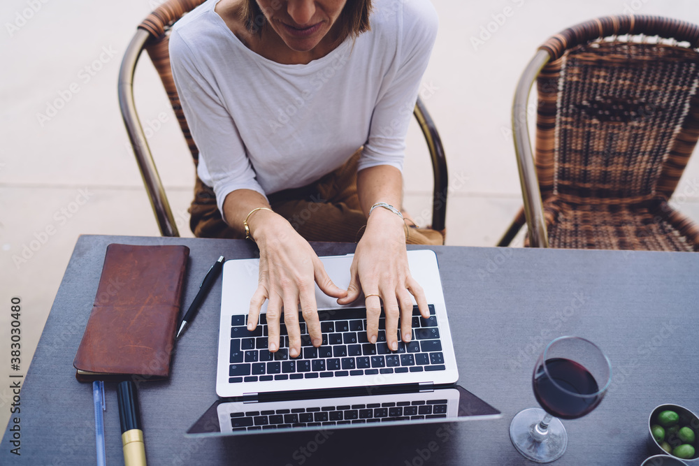 Poster top view of female sitting on cafe interior with laptop computer searching information and browsing 