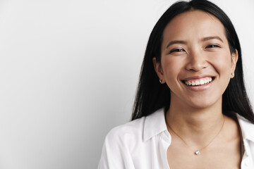 Photo of happy asian woman laughing and looking at camera
