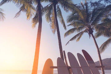 Surfboard and palm tree on beach background.