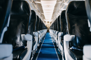 Empty airplane cabin with selective focus on armrests.