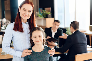 Fototapeta premium Woman is standing in foreground and hugging girl