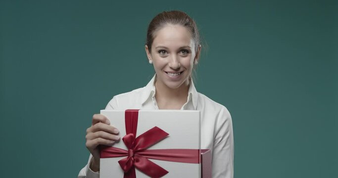 Happy young woman opening a gift box