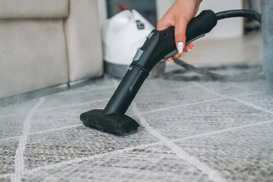 Woman Cleaning Carpet With A Steam Cleaner