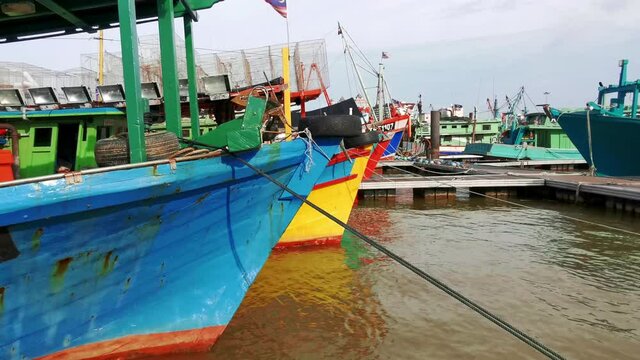 Static view of colorful traditional wooden fishing boat docking at a jetty in Kuala Terengganu, Malaysia.