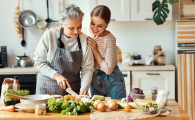 Happy mother and daughter preparing healthy food at home - 383038023