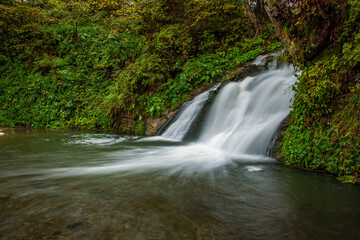 Wonderful waterfall on the mountain river Carpathians. Hurkalo Waterfall, Carpathian Mountains, National Park of Skole Beskydy, Ukraine. Carpathian river, fast current, crystal water. Long exposu