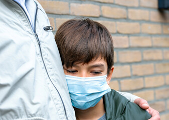 portrait of a teenage boy in a medical mask. A sickness boy with a fever in a medical mask standing...