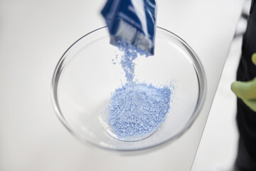 Transparent bowl being filled with blue powder