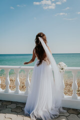 the bride stands on the background of the sea