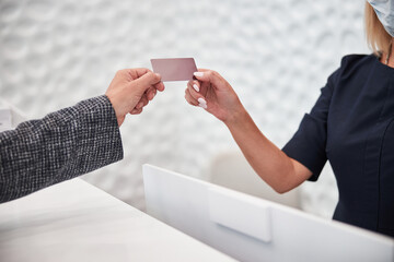 Customer of a shop receiving a plastic discount card
