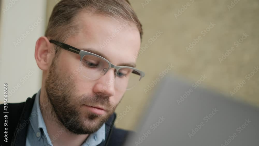 Poster remote job. a man is working with documents on laptop remotely at home. a business man is using comp