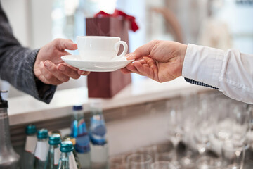 Cup with a hot beverage being passed to a customer
