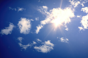 typical blue sky with sun and clouds background