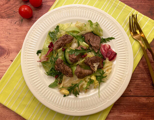 Tender grilled beef filet strips served over mixed salad with balsamic dressing. Summer classic steak salad.