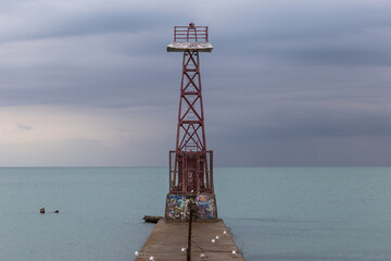 Fototapeta na wymiar Beacon on pier of Lake Michigan during a storm with foreboding clouds