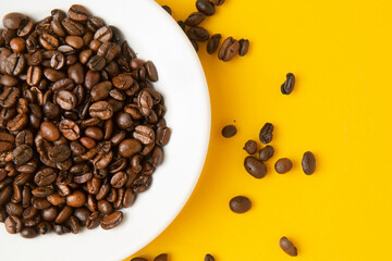 coffee beans on saucer with yellow background