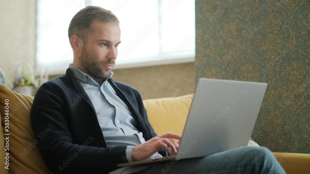 Poster remote job. a man is working with documents on laptop remotely at home. a business man is using comp