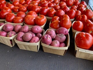 baskets of red potatoes and tomatoes at the market