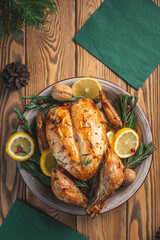 Baked chicken with rosemary and berries on a wooden table. Traditional Christmas dish for a festive dinner. Top view