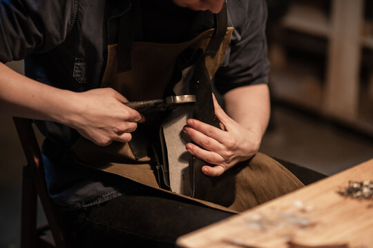 a hereditary shoemaker makes shoes from leather in the family workshop