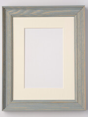 vertical gray-blue wooden photo frame with light mat with free space for insertion.