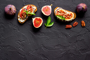Sandwiches with figs, cheese and honey on table