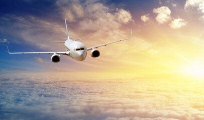 Fototapeta na wymiar Passengers commercial airplane flying above clouds in sunset.