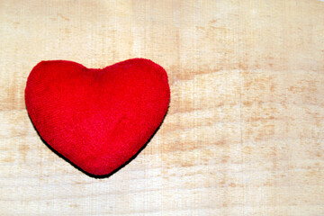 Fototapeta premium red plush heart on a wooden background.