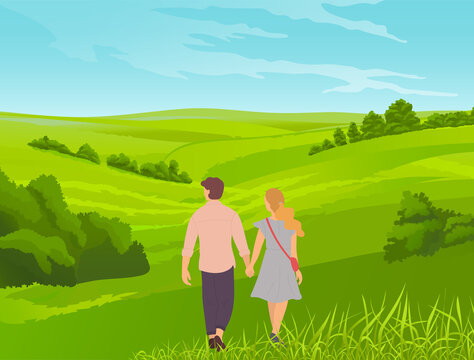 Young romantic couple walks in park or field. Grass in the foreground, bushes, thickets, valley. Walking the countryside, tourist route, picturesque landscape with young married couple or teenagers