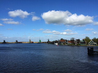 Naklejka premium dutch historic windmills near sea coast at blue sky, in Zaanse Schans, North Holland, Netherlands