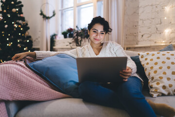 Smiling woman using laptop in Christmas day