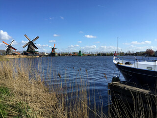 dutch historic windmills near sea coast at blue sky, in Zaanse Schans, North Holland, Netherlands