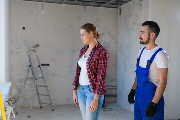 The builder shows the female customer the renovation of the apartment. She is unhappy