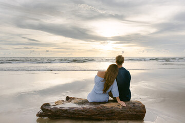 Coppia innamorata sulla spiaggia al tramonto - obrazy, fototapety, plakaty