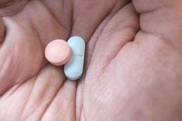 Close up of man hand taking medicine 